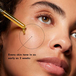 Person applying SkinCeuticals Discoloration Defense serum to face for even-looking skin tone